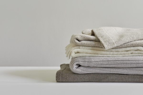 LUIZ_Home_slider_Roadshow LUIZ Plaids-Stapel in Naturtönen und exklusiven Materialien.